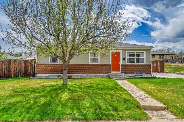 a front view of a house with a yard and trees