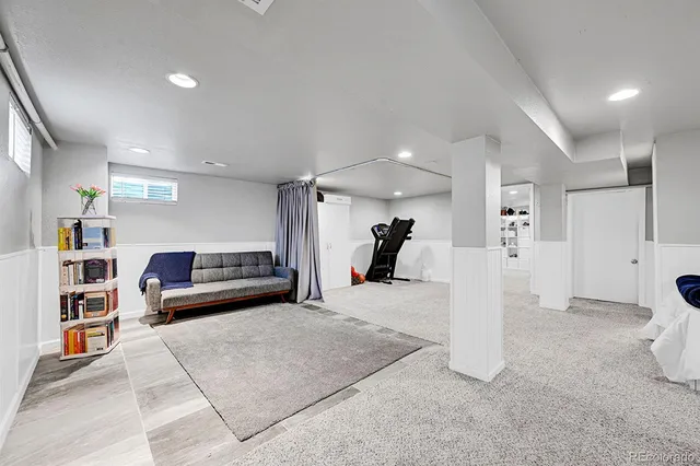 a living room with furniture and a book shelf