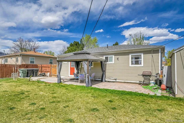 a view of a house with backyard and sitting area