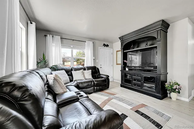 a living room with a bed and a television