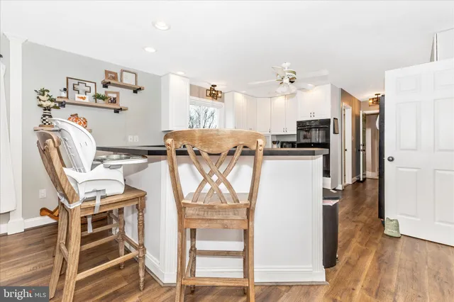 a kitchen with granite countertop white cabinets and white appliances