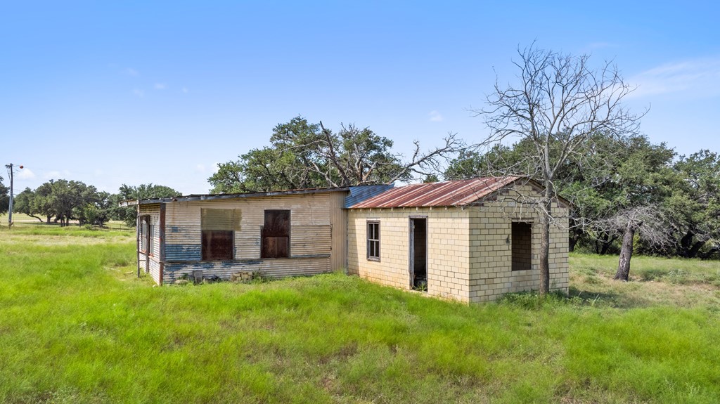 131 Elberta Street Stonewall, TX 78671 - Photo 16 of 71 a view of a house with a backyard and a garden