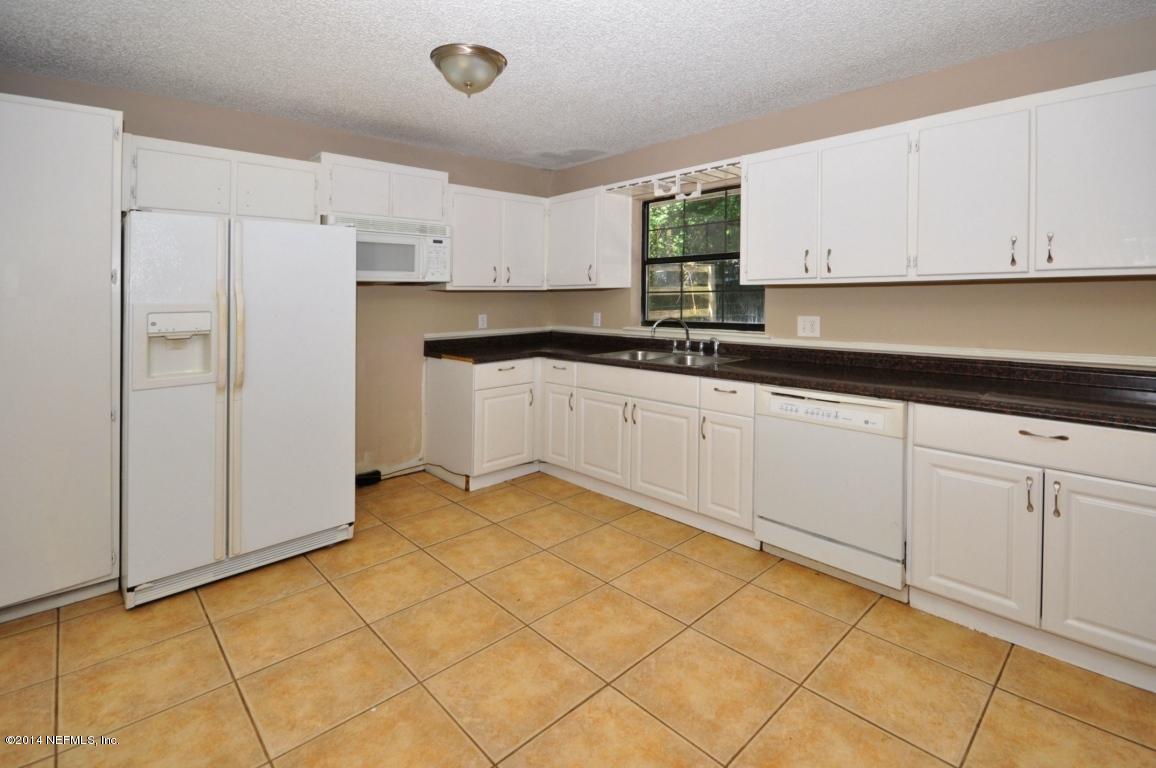 450 Orchis Road St. Augustine, FL 32086 - Photo 6 of 18 a kitchen with granite countertop white cabinets and white appliances