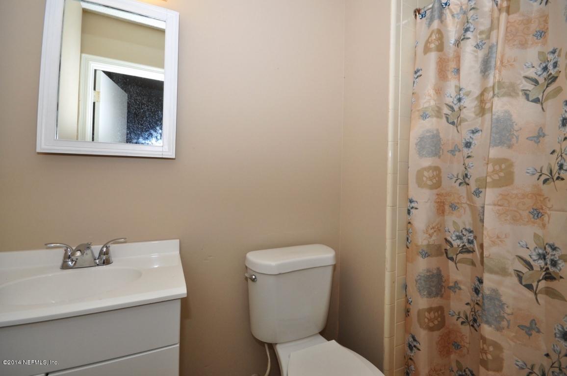 450 Orchis Road St. Augustine, FL 32086 - Photo 9 of 18 a bathroom with a toilet sink and mirror