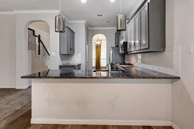 a kitchen with stainless steel appliances granite countertop a sink stove and microwave