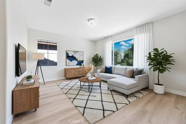 a living room with furniture a flat screen tv and a large window