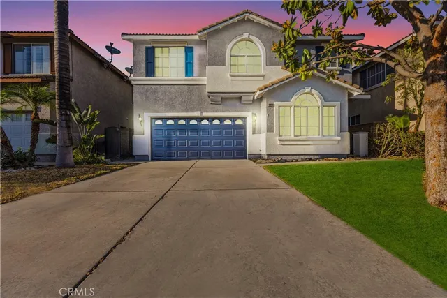 a front view of a house with a yard and potted plants