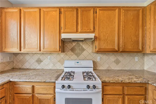 a kitchen with granite countertop cabinets washer and dryer