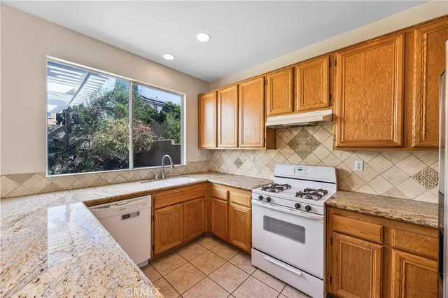 a kitchen with a stove a sink and cabinets