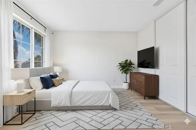 a bedroom with a bed a couch and a flat screen tv