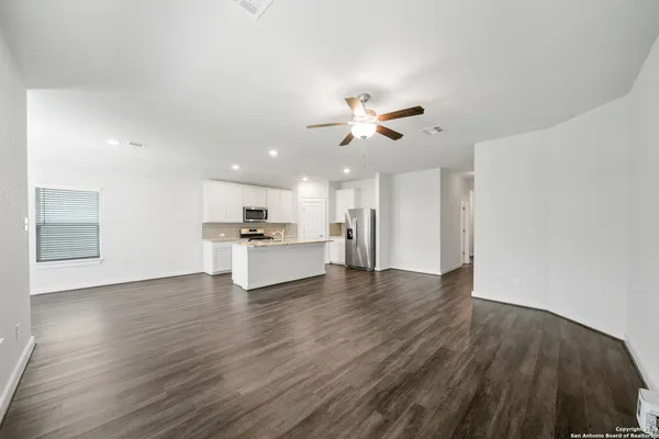 a view of kitchen with a sink dishwasher a refrigerator with wooden floor and a kitchen view