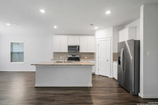 a kitchen with stainless steel appliances a refrigerator and a stove top oven