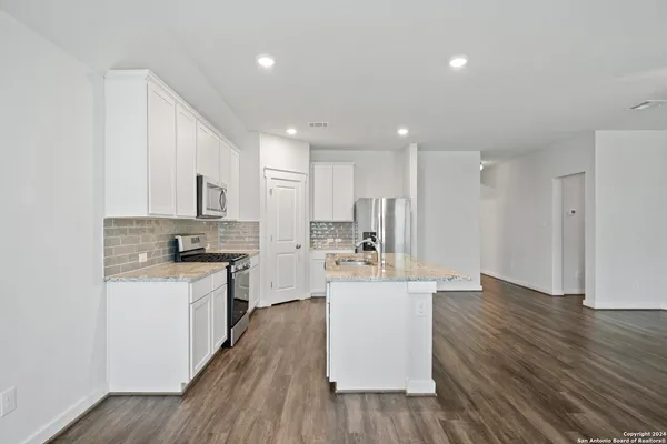 a kitchen with stainless steel appliances a white stove top oven sink and cabinets