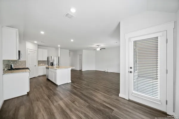 a living room with kitchen island furniture and a wooden floor