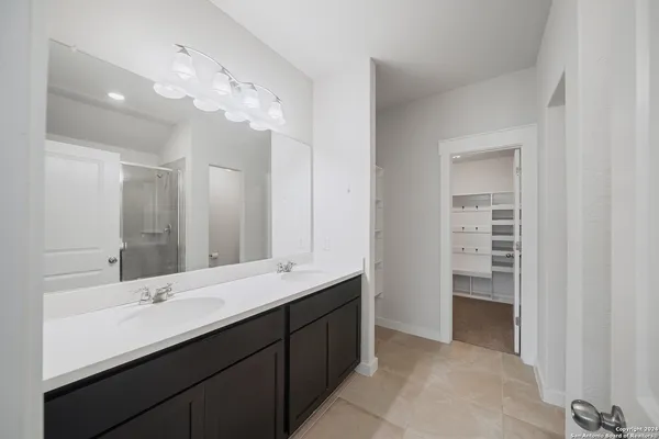 a bathroom with a double vanity sink and a mirror