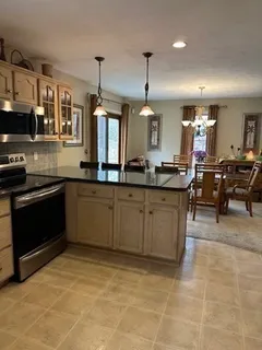 a kitchen with stainless steel appliances granite countertop a sink a stove top oven a counter space and cabinets