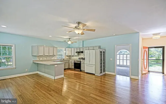 a open kitchen with stainless steel appliances granite countertop a refrigerator stove top oven and sink