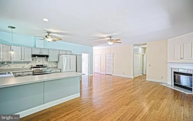 a large kitchen with cabinets wooden floor and stainless steel appliances