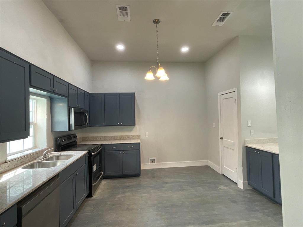 207 College Street Chico, TX 76431 - Photo 12 of 20 Kitchen featuring appliances with stainless steel finishes, pendant lighting, light stone countertops, a chandelier, and recessed lighting