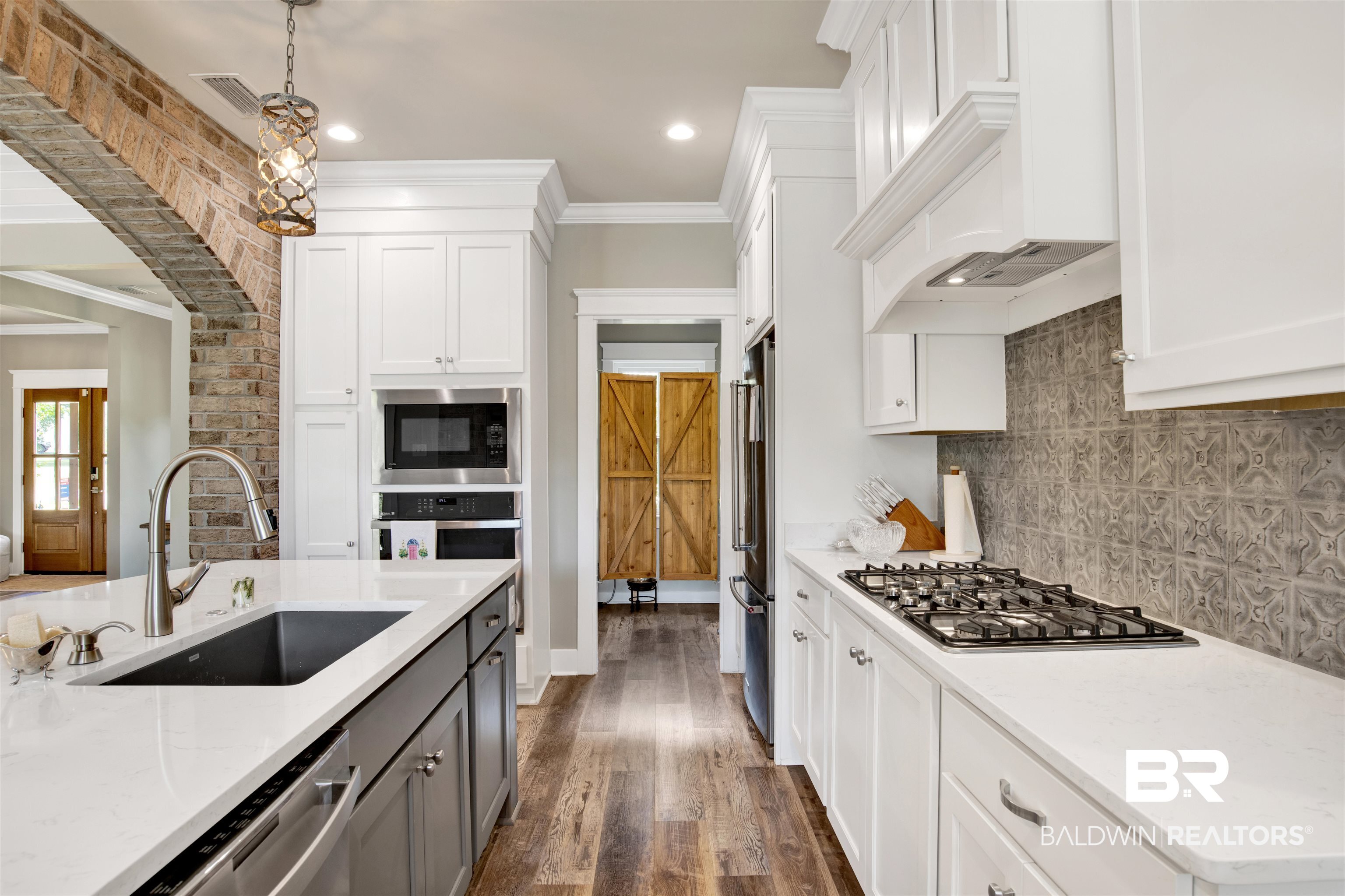 21621 Veranda Boulevard Fairhope, AL 36532 - Photo 22 of 51 Kitchen with a sink, appliances with stainless steel finishes, crown molding, and white cabinets