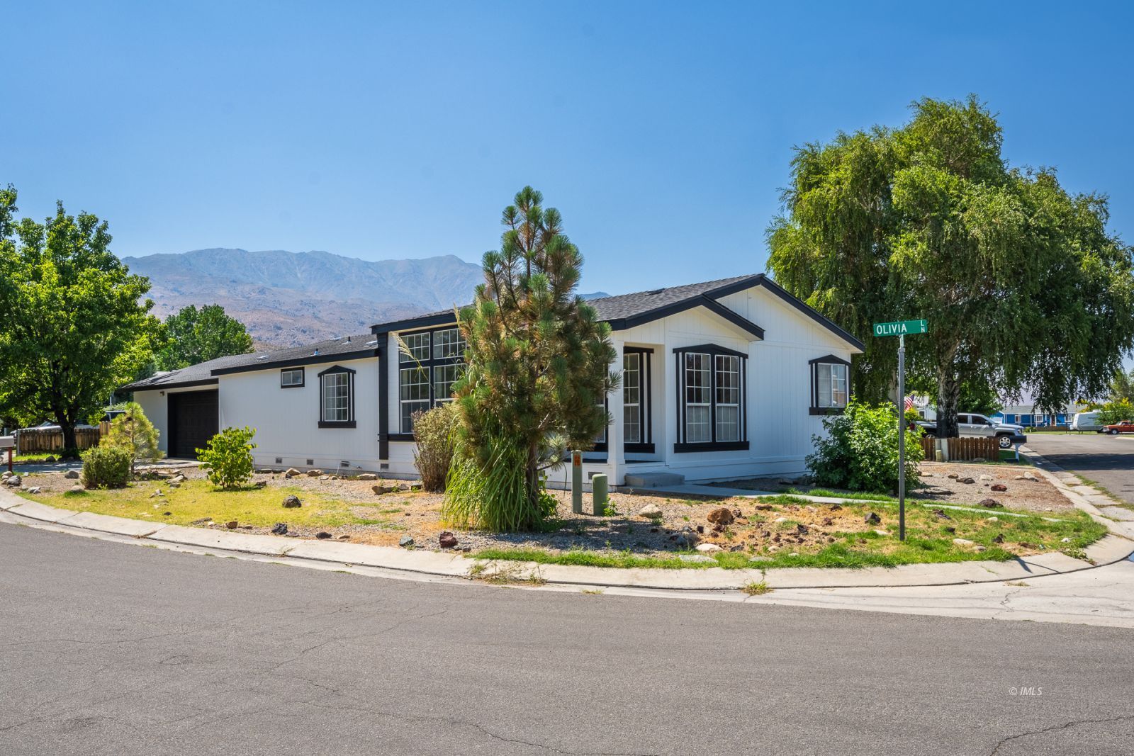 a front view of house with yard and trees in the background