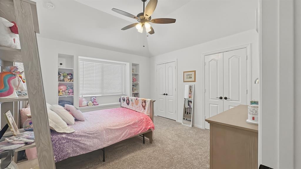 5216 Troupe Road McKinney, TX 75071 - Photo 33 of 40 Room featuring a vaulted ceiling with a ceiling fan, carpet flooring, a window with blinds, and built-in shelving on either side