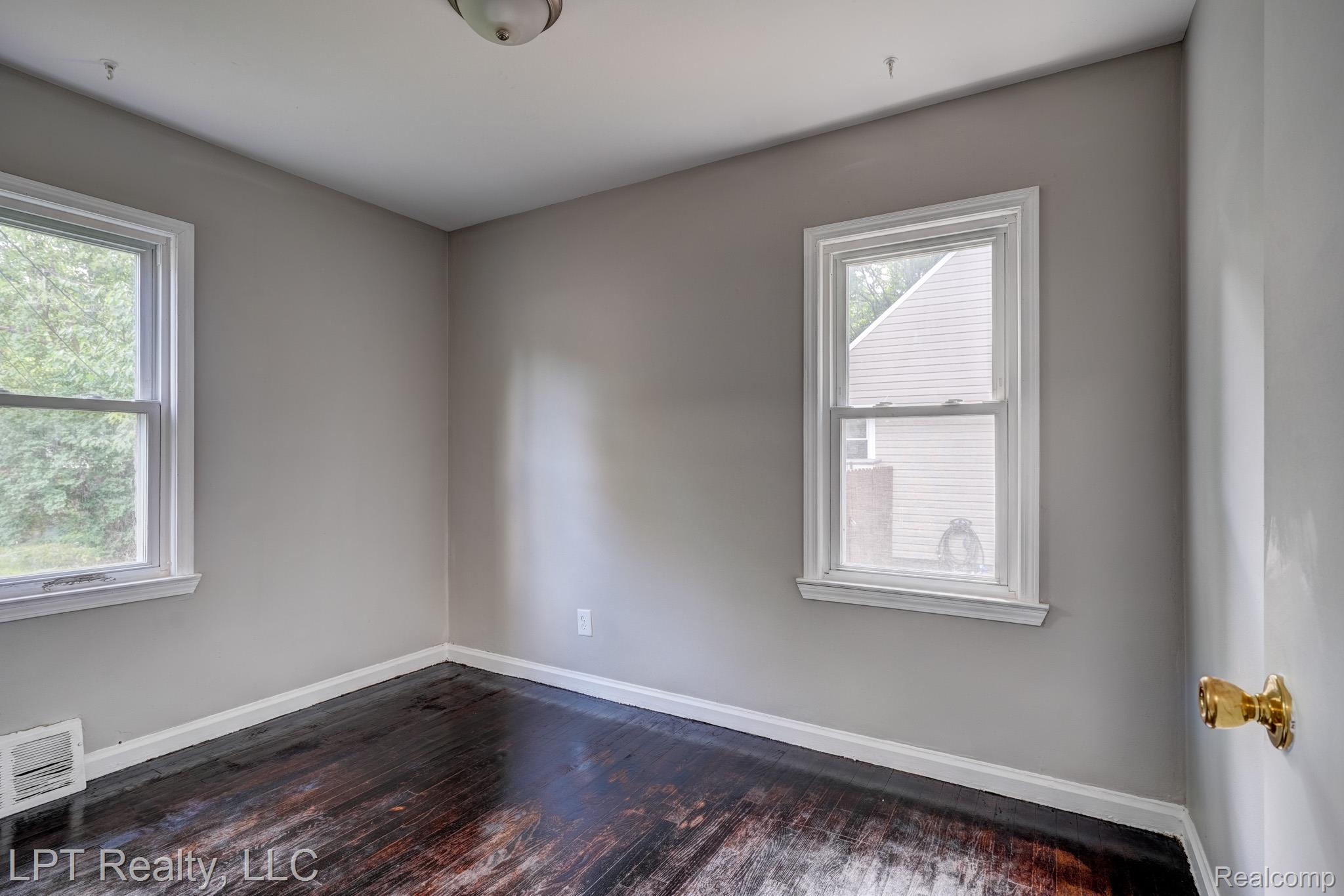 23038 Violet Street Farmington, MI 48336 - Photo 15 of 29 Room featuring two windows with white trim, dark wood-finish flooring, light grey walls, white baseboards, and a ceiling-mounted light fixture