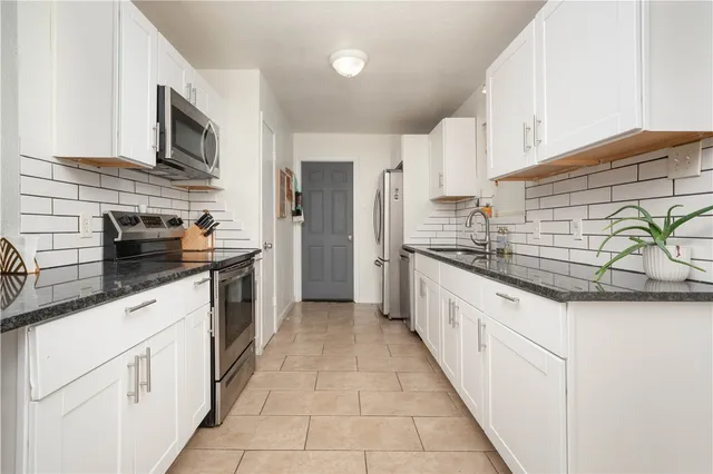 a kitchen with stainless steel appliances a stove and a microwave