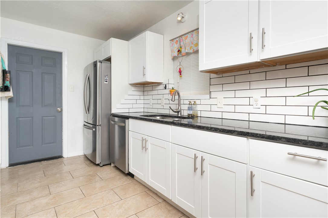 9566 Waxwing Street Corpus Christi, TX 78418 - Photo 13 of 20 a kitchen with stainless steel appliances granite countertop a sink and a refrigerator