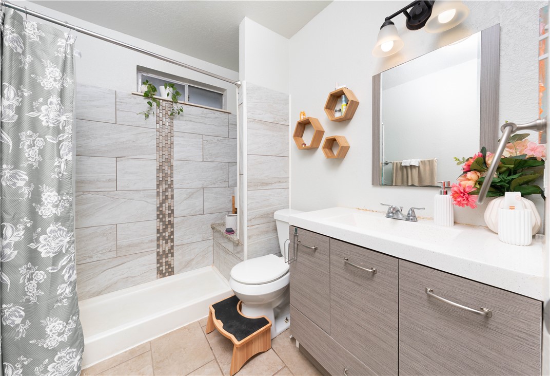 9566 Waxwing Street Corpus Christi, TX 78418 - Photo 18 of 20 a bathroom with a sink a toilet and shower