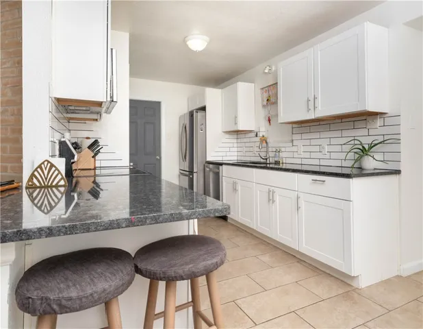 a kitchen with stainless steel appliances a sink dishwasher stove refrigerator and cabinets