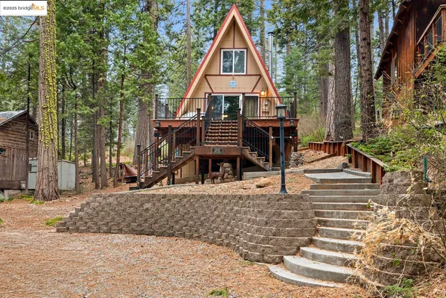 a view of house with backyard and trees in the background
