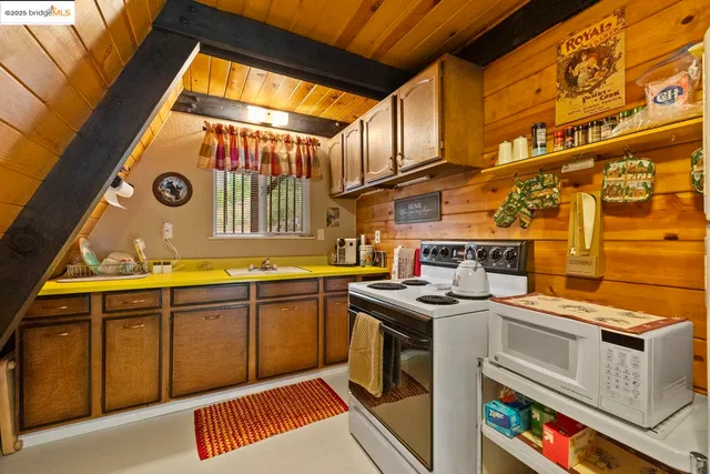 a utility room with stainless steel appliances granite countertop a sink and a cabinets