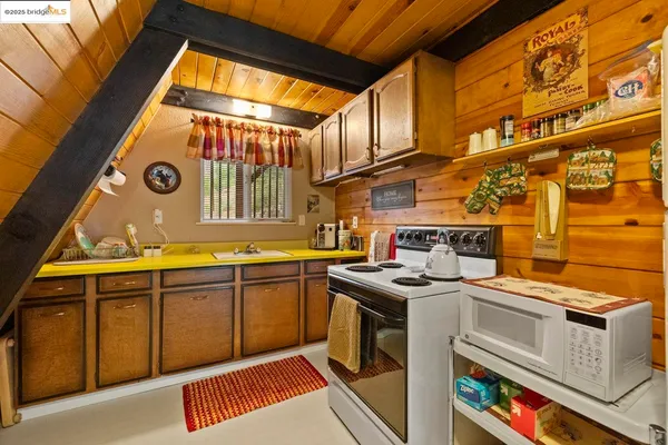 a utility room with stainless steel appliances granite countertop a sink and a cabinets