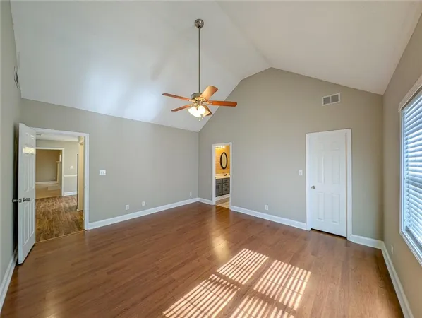 a view of an empty room with window and wooden floor