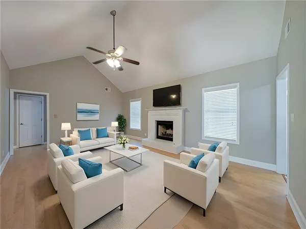 a living room with furniture a fireplace and a ceiling fan