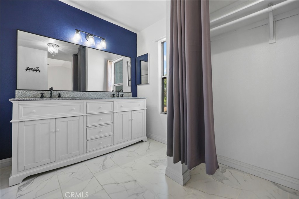 4117 East Ave R 13 Palmdale, CA 93552 - Photo 11 of 16 a bathroom with a granite countertop sink and a mirror