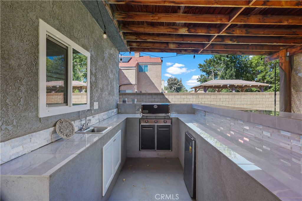 4117 East Ave R 13 Palmdale, CA 93552 - Photo 13 of 16 a kitchen with stainless steel appliances granite countertop a sink and a stove