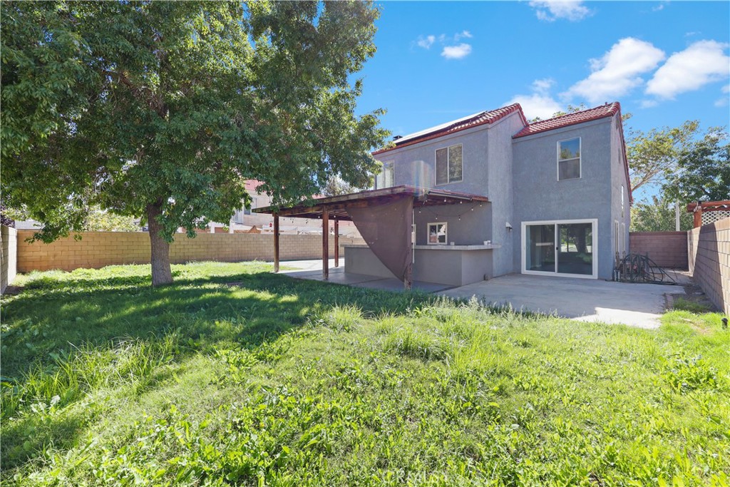 4117 East Ave R 13 Palmdale, CA 93552 - Photo 14 of 16 a view of a house with a backyard and a large tree