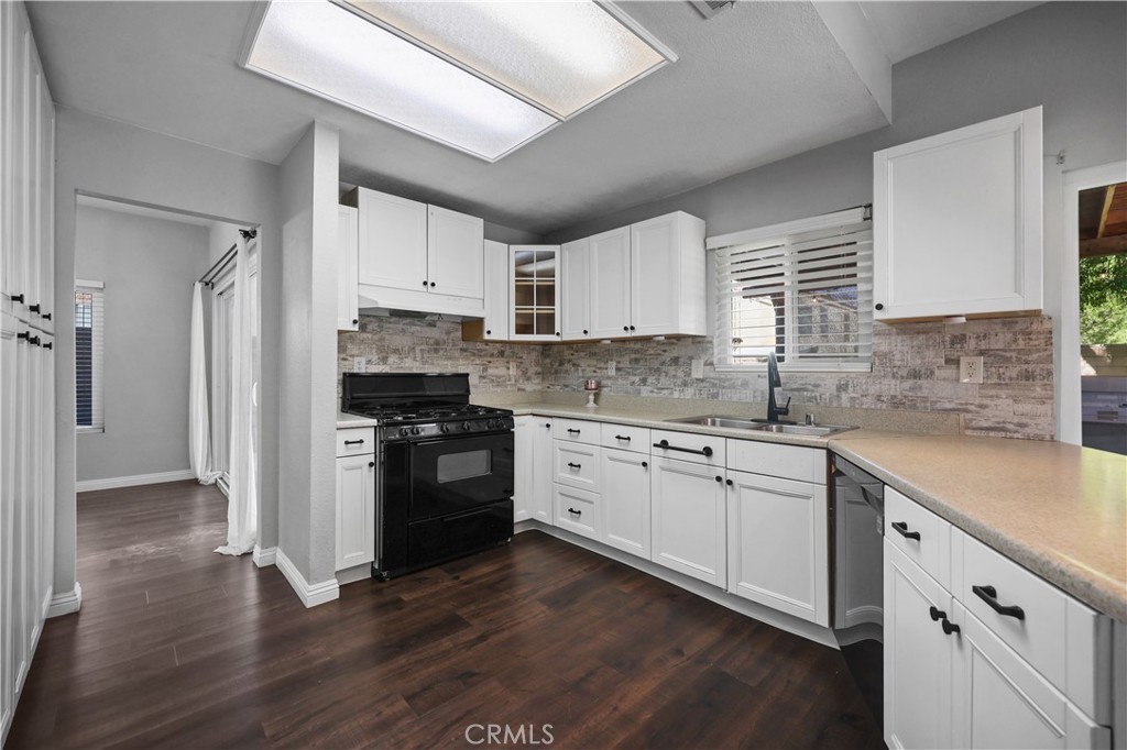 4117 East Ave R 13 Palmdale, CA 93552 - Photo 3 of 16 a kitchen with granite countertop white cabinets white appliances and sink