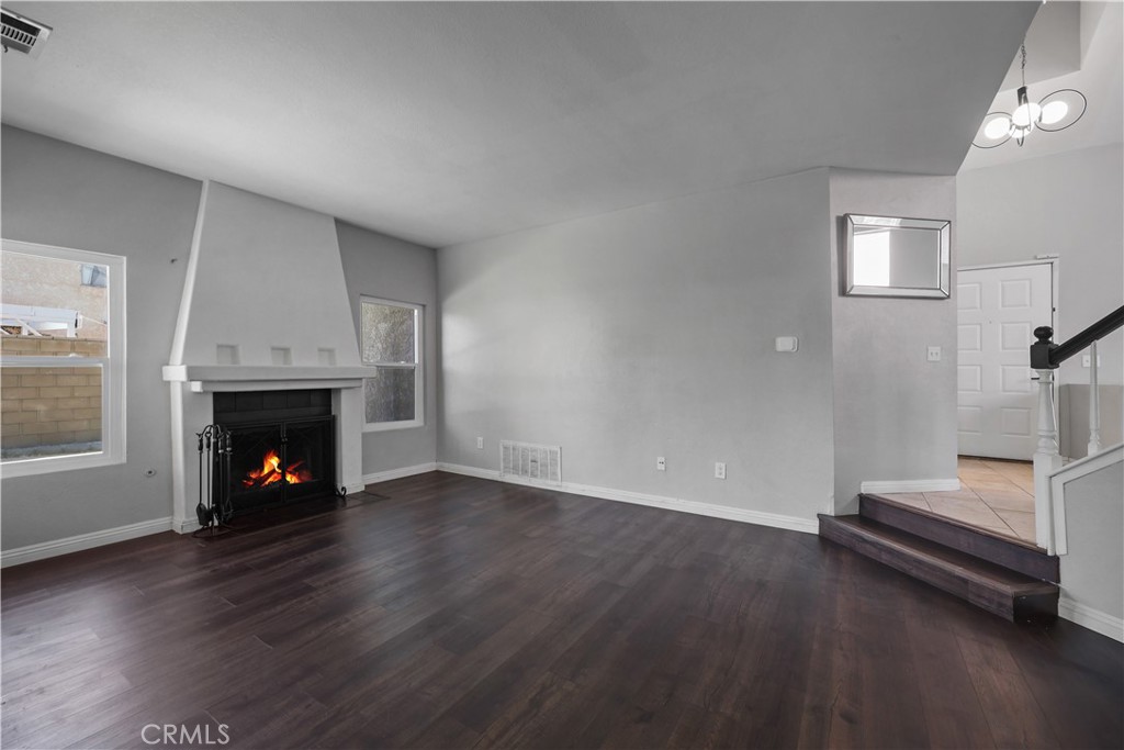 4117 East Ave R 13 Palmdale, CA 93552 - Photo 7 of 16 an empty room with wooden floor fire place and windows