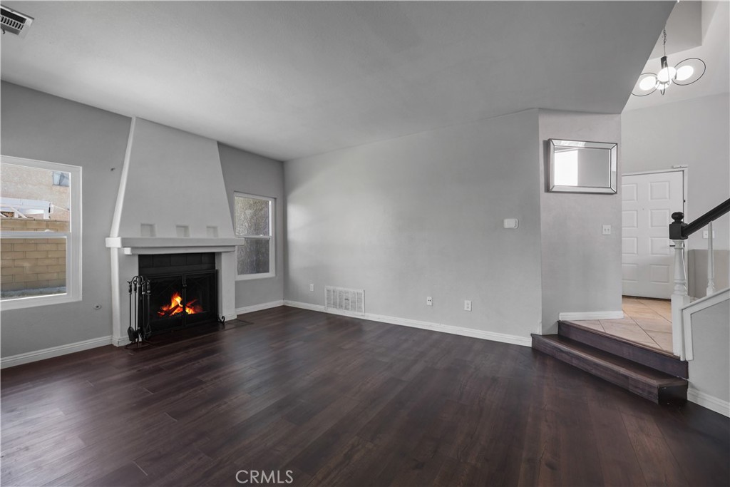4117 East Ave R 13 Palmdale, CA 93552 - Photo 9 of 16 an empty room with wooden floor fire place and windows