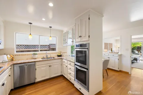 a kitchen with white cabinets and white appliances