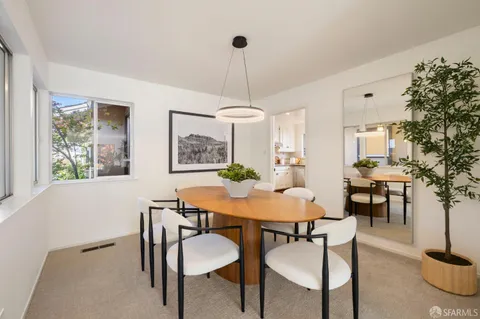 a dining room with furniture a chandelier and window