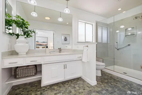 a bathroom with a sink a toilet and shower