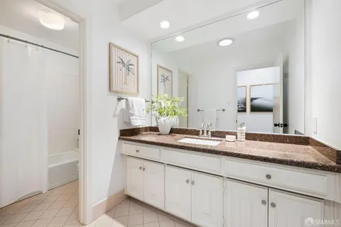 a bathroom with a granite countertop double vanity sink mirror and