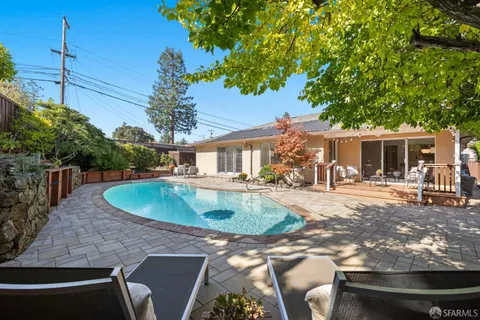 a view of a house with backyard sitting area and swimming pool