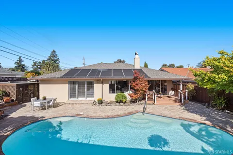 a view of a house with swimming pool and sitting area