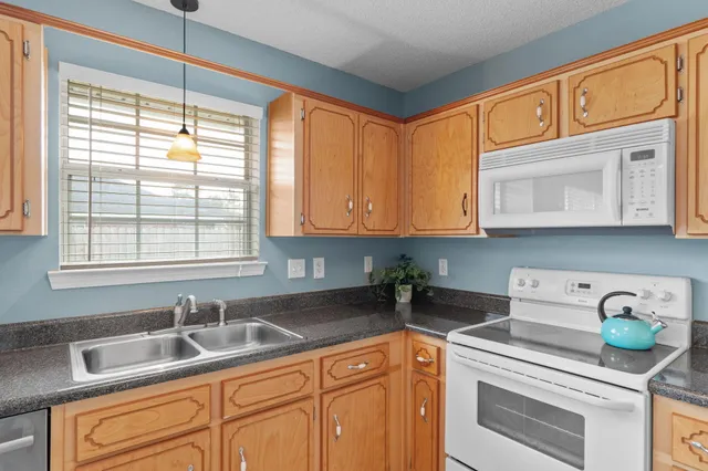 a kitchen with stainless steel appliances granite countertop a sink a stove and cabinets