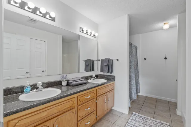 a bathroom with a double vanity sink and a mirror